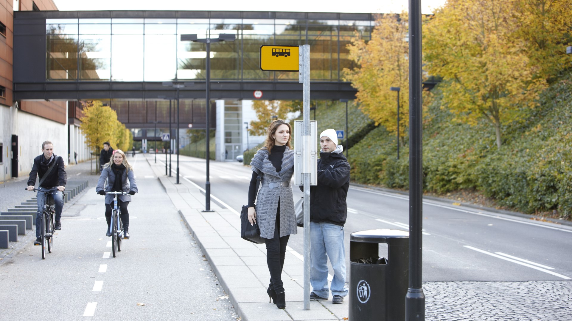 People by busstop and on bikes